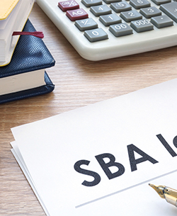 sba loan document next to paperwork and calculator